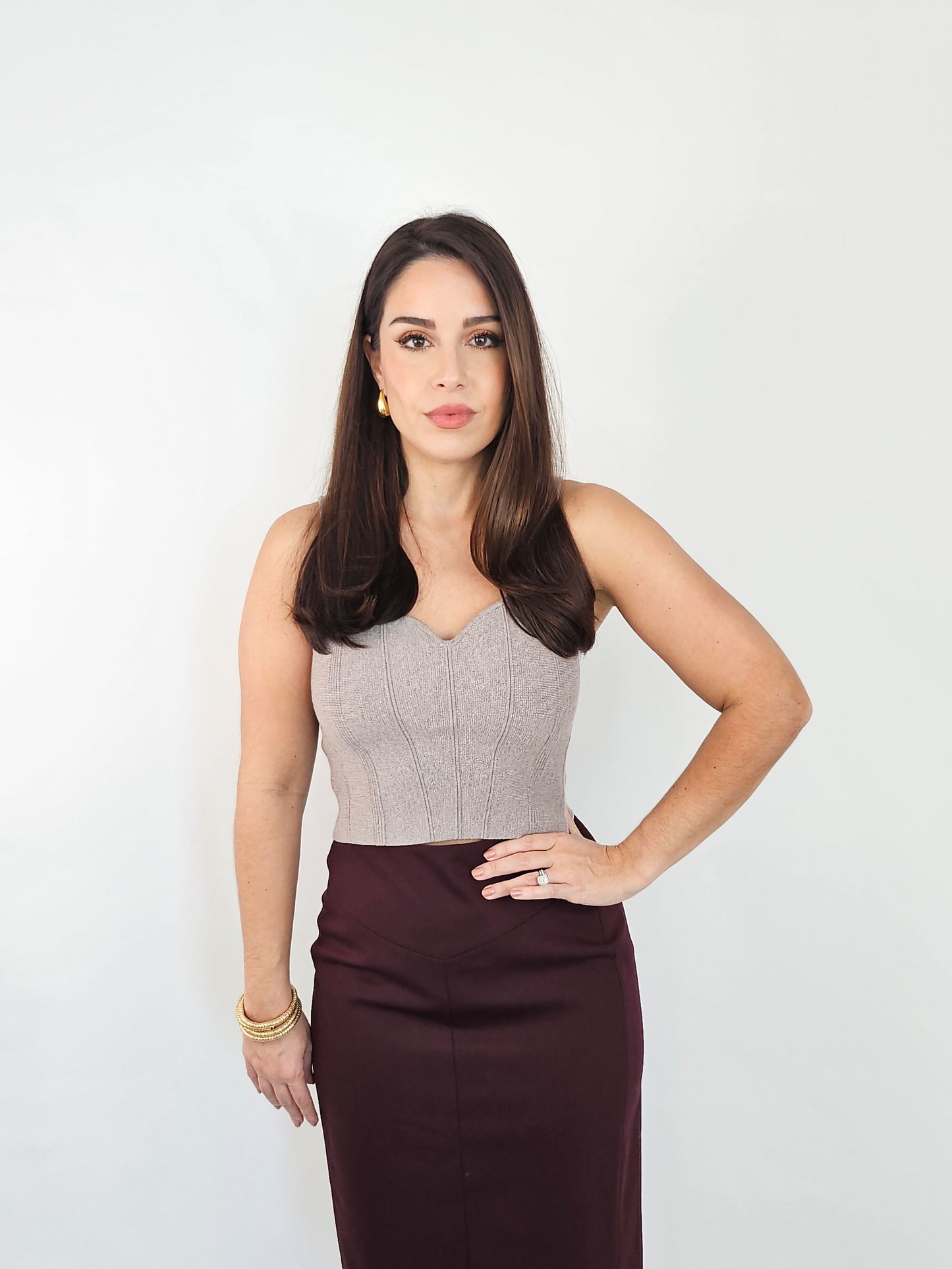 Showing a full length photo of the sleeveless knit top and how it looks paired with a workwear pencil skirt for a more polished look.