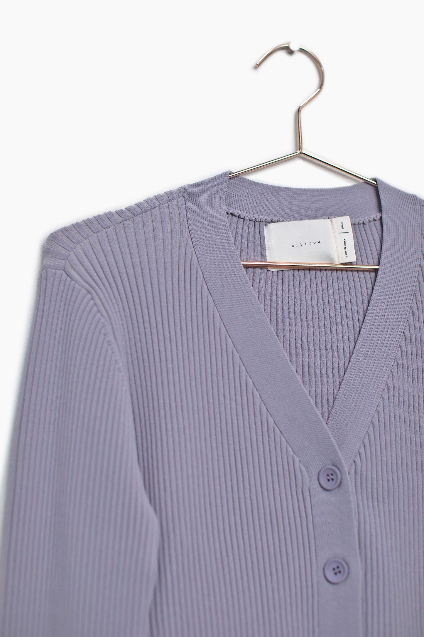 Close up of the button up cardigan sweater showcasing the features of the quality and how thick it is with the fabric.